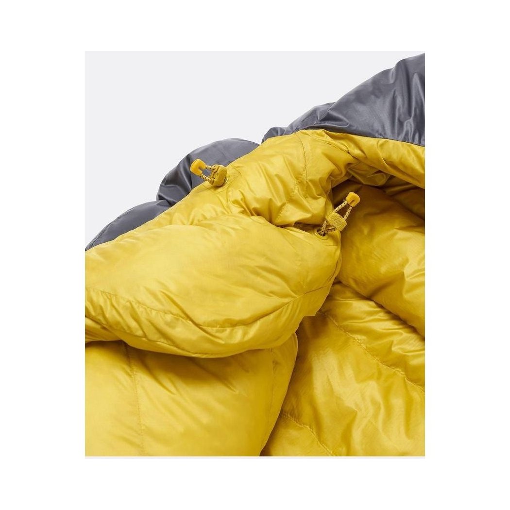 A close-up of the Rab Neutrino 0C / 32F sleeping bag in Graphene/Dark Pollen showing the yellow down filling and gray outer shell against a white background.