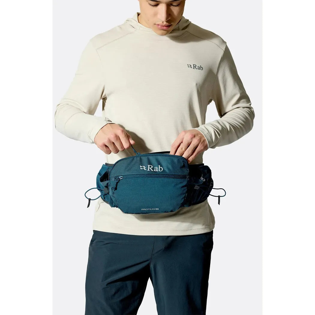 A model wears the Rab Protium 6 waist pack in Anthracite against a plain white background.