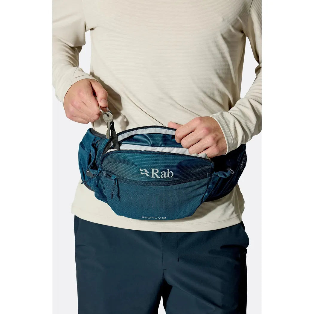 A model wears the Rab Protium 6 waist pack in Anthracite against a plain white background.