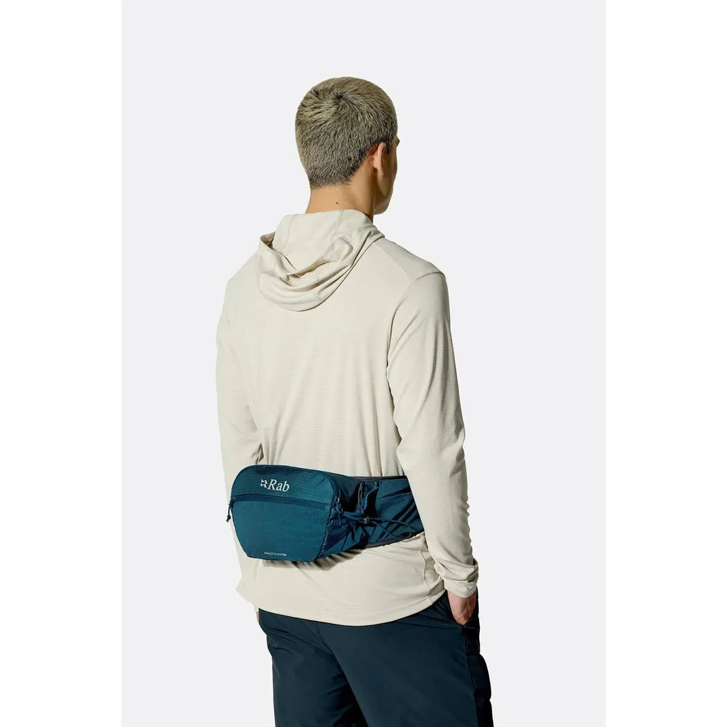 Back view of the Rab Protium 6 in Anthracite on a model wearing a light hoodie against a plain white background.