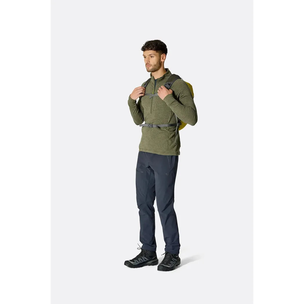 Side view of the Rab Tygen 12 backpack in Black worn by a model against a plain white background.