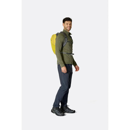 Side view of the Rab Tygen 12 backpack in Black worn by a model against a plain white background.