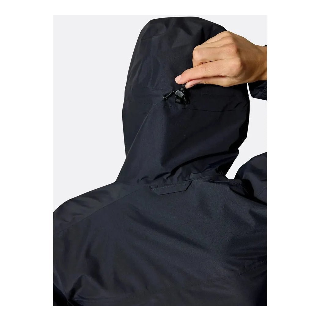 A close-up of the Rab Women's Downpour Jacket in Black, showing the hood and a hand adjusting the drawcord against a plain white background.