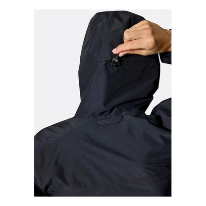A close-up of the Rab Women's Downpour Jacket in Black, showing the hood and a hand adjusting the drawcord against a plain white background.