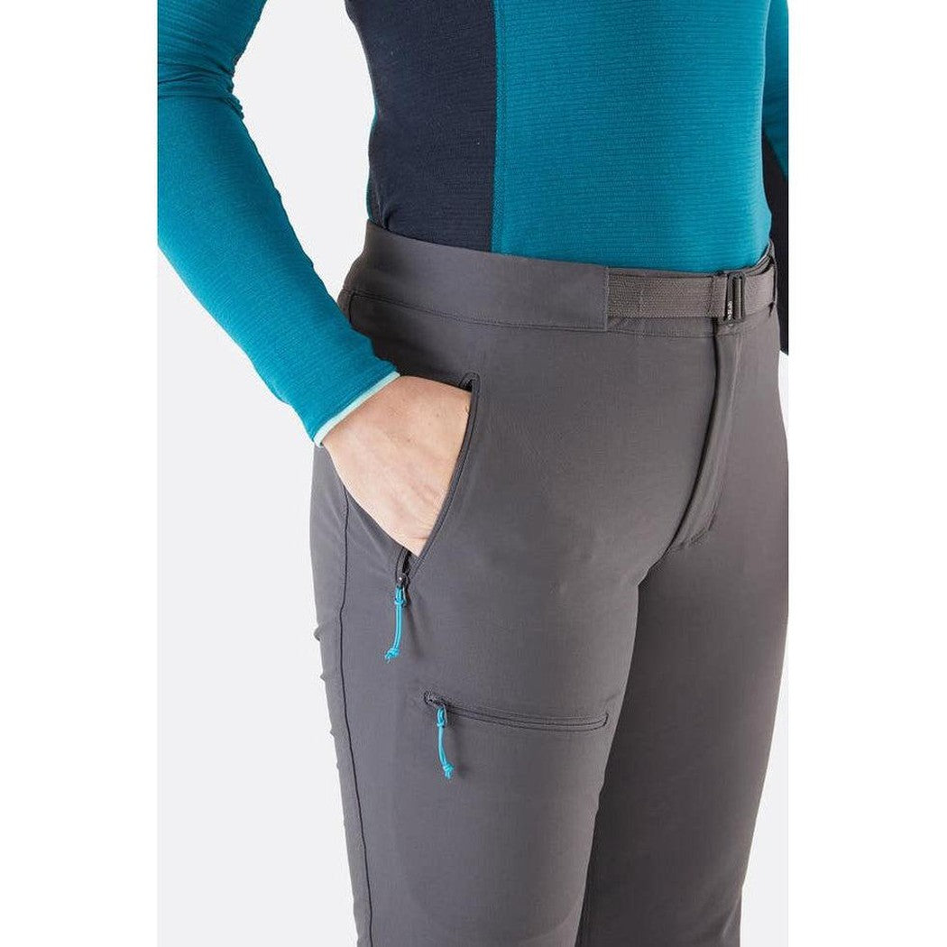 Side view of the Rab Women's Incline AS Pants in Graphene showing the zippered pocket and model wearing them against a white background.