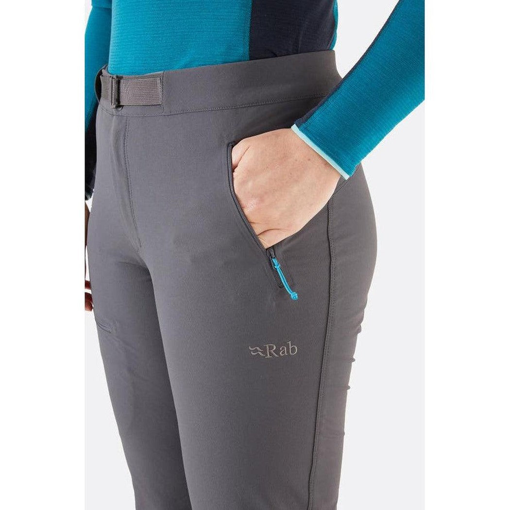 Side view of the Rab Women's Incline AS Pants in Graphene showing the zippered pocket and model wearing them against a white background.