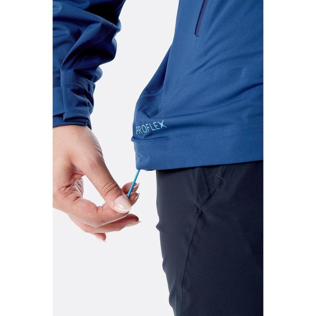 A close-up of the Rab Women's Kinetic 2.0 Jacket in Ultramarine showing the model's hand adjusting a pull cord near the hem.