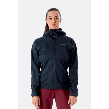 A front view of the Rab Women's Kinetic 2.0 Jacket in Ultramarine on a model wearing maroon pants against a plain white background.