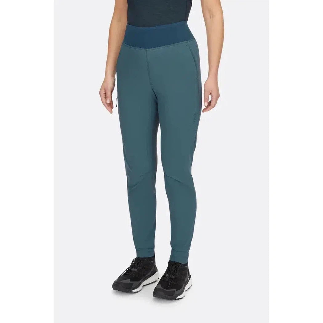 A front view of the Rab Women's Momentum Pants in Beluga color, showing the high waistband and model wearing black sneakers against a plain white background.