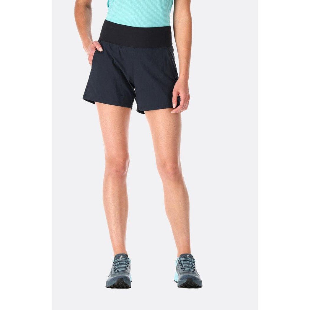 A front view of the Rab Women's Momentum Shorts in Beluga color, showing the high waistband and pockets, with a model wearing them against a plain white background.