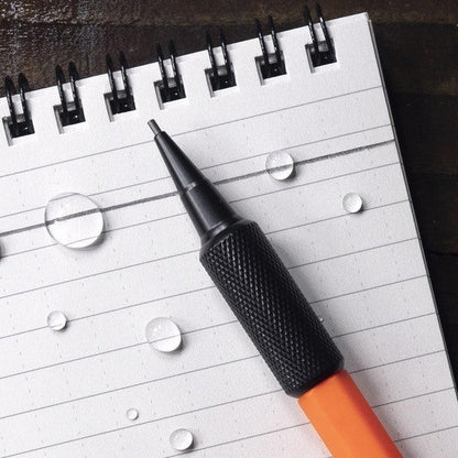 A close-up of the Rite in the Rain 1.3mm Mechanical Clicker Pencil in Black on a lined notebook with water droplets.