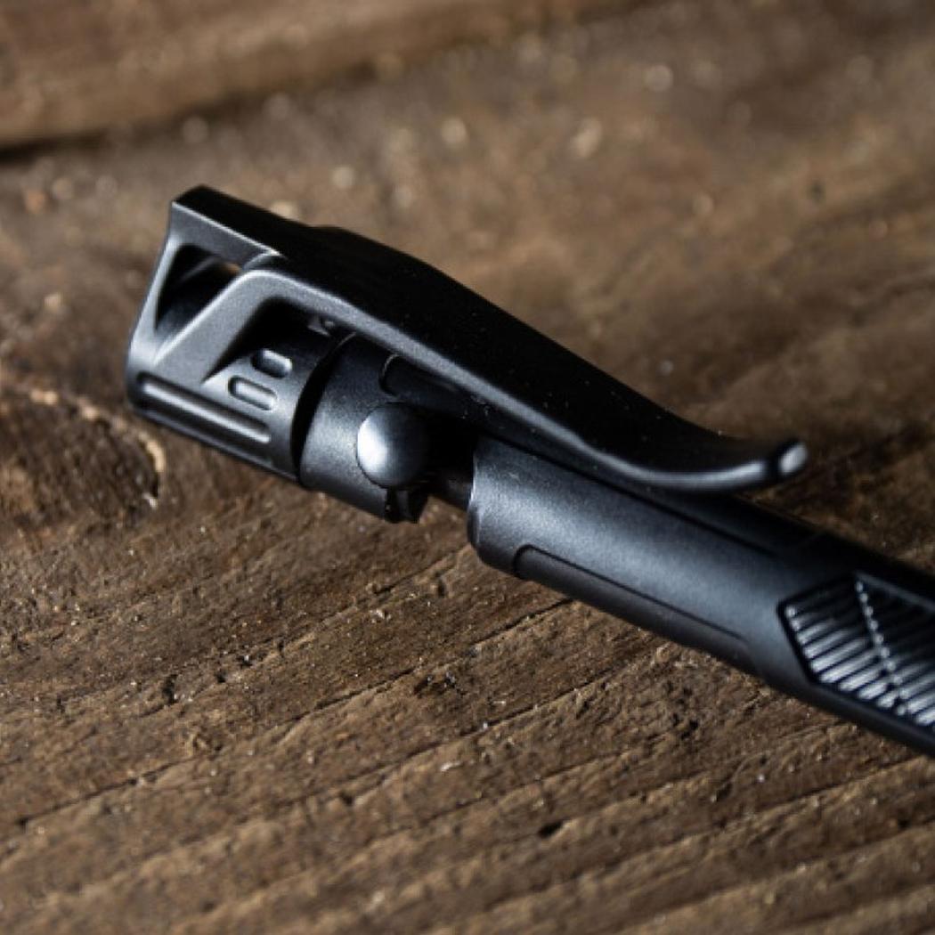 Close-up of the Rite in the Rain Mini Bolt-Action Pen in Black, showing the clip and textured grip against a wooden background.