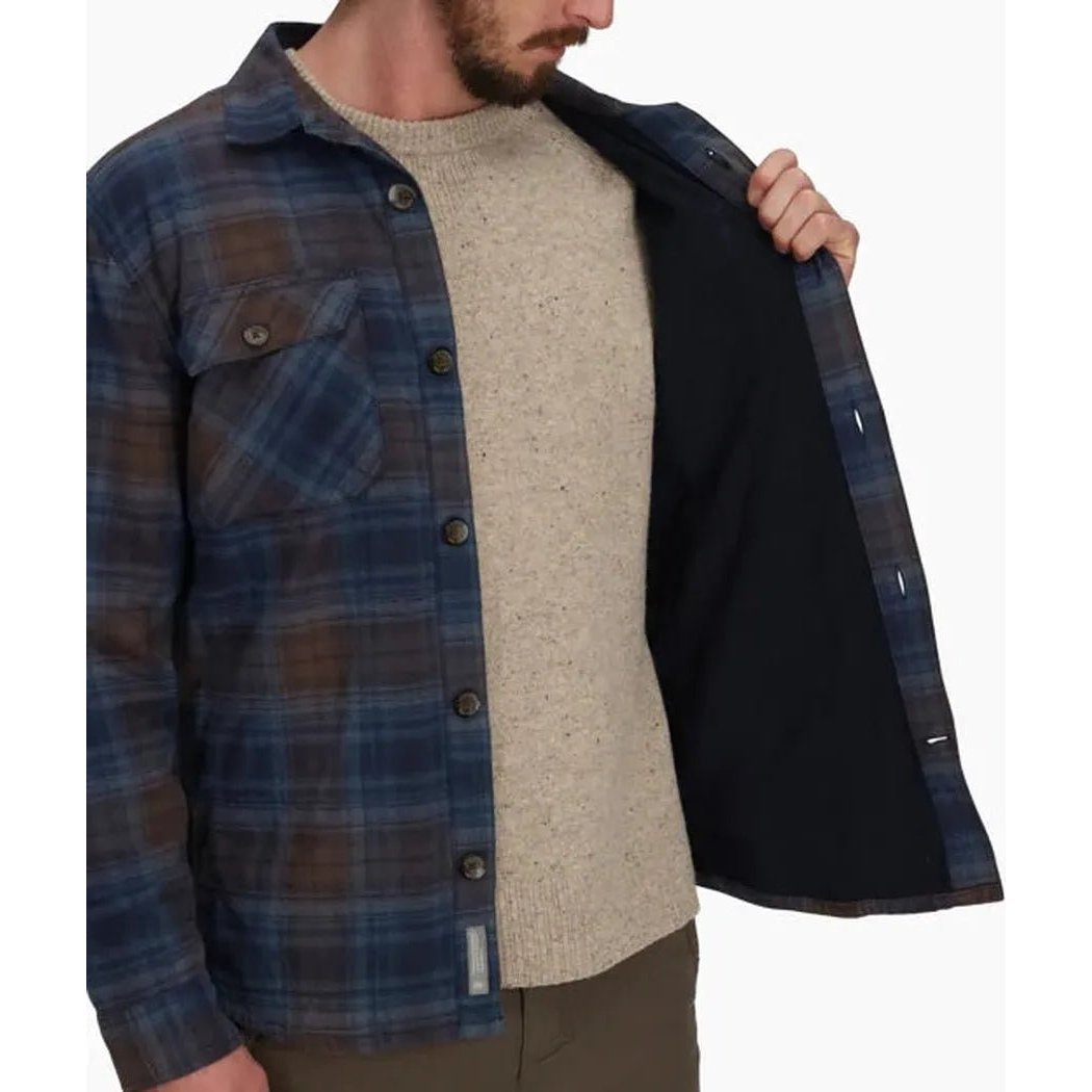 A man wearing the Royal Robbins Men's Snowcap Lined Flannel in Navy Tioga Pld shows the dark lining from the open front against a plain white background.