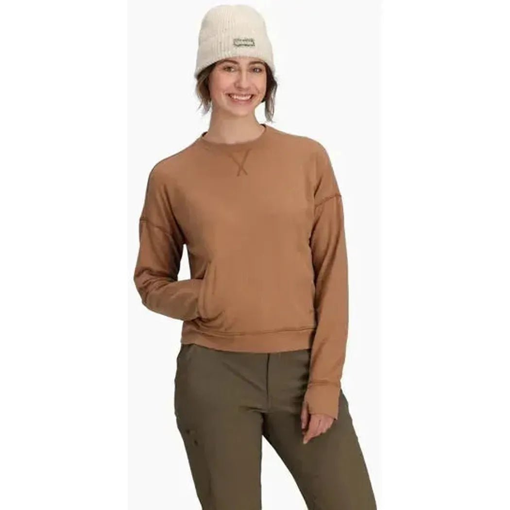 A front view of the Royal Robbins Women's Avonelle Sweatshirt in Tawny on a model wearing olive pants and a white beanie against a white background.