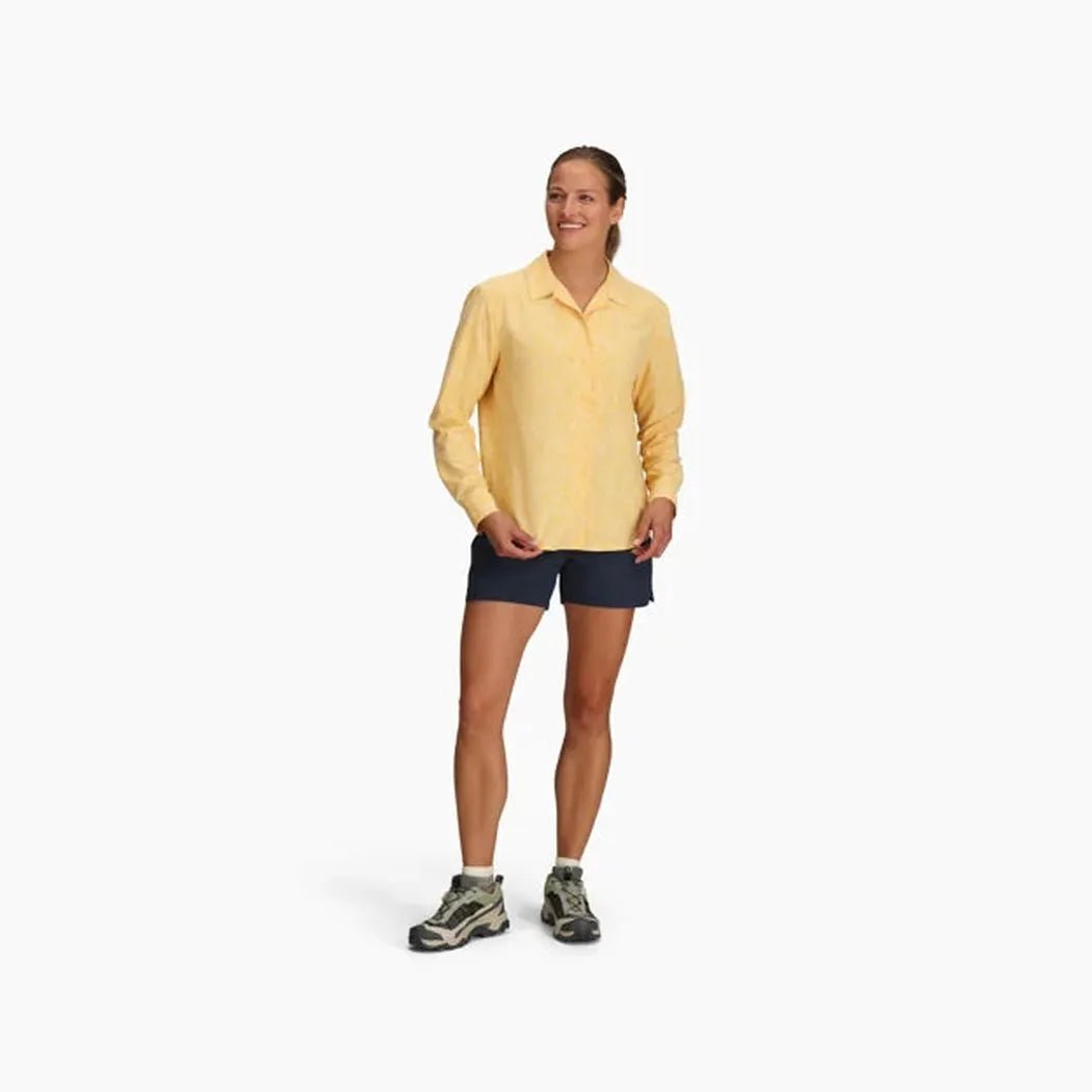 A woman wearing the Royal Robbins Women's Salathe Sun Shirt Long Sleeve in Lime Cream stands against a white background.