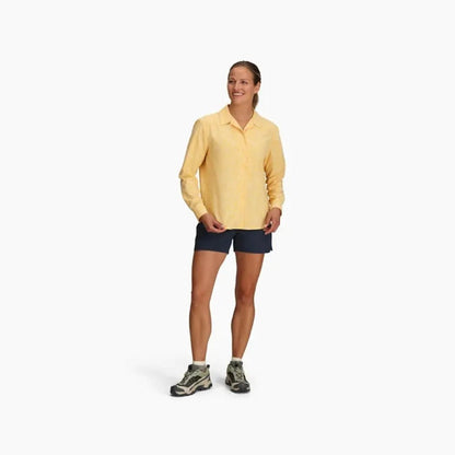 A woman wearing the Royal Robbins Women's Salathe Sun Shirt Long Sleeve in Lime Cream stands against a white background.