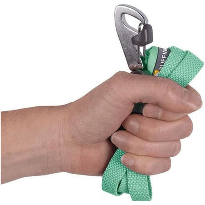A hand holds the Sage Green Ruffwear Hi & Light Leash with a metal carabiner attached, against a plain white background.