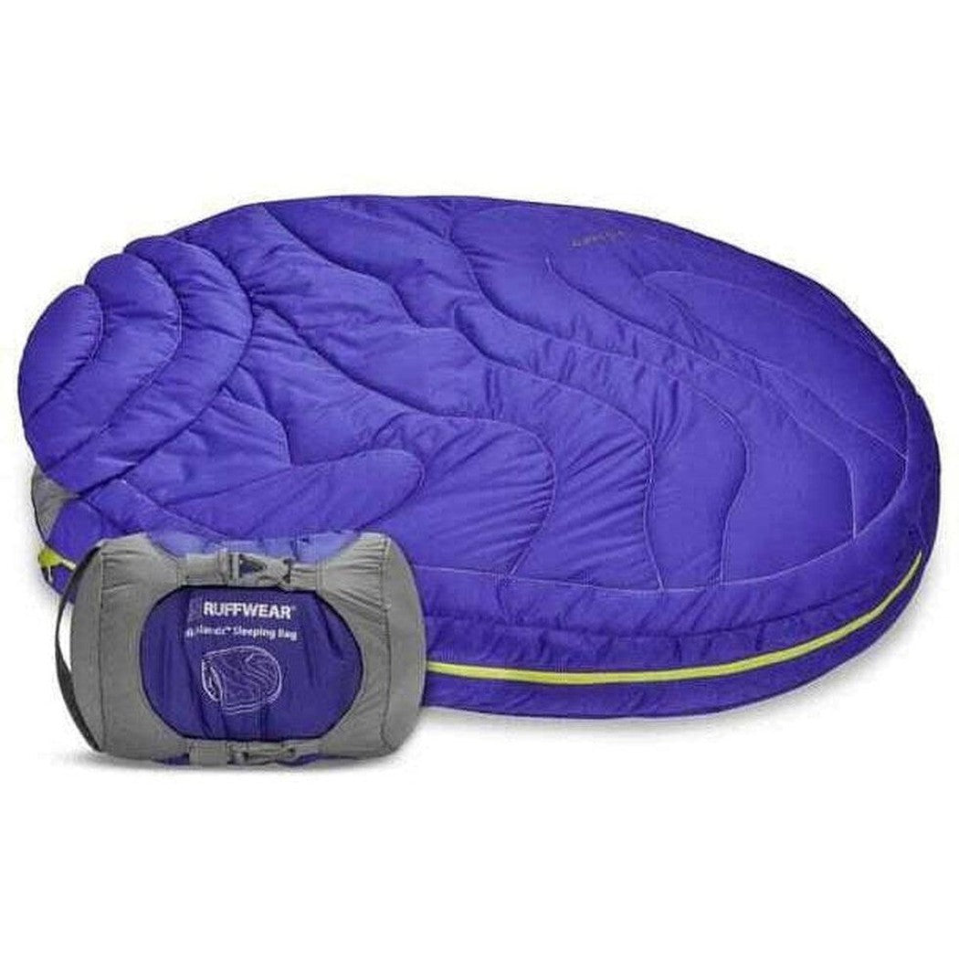 A full view of the Ruffwear Highlands Dog Sleeping Bag in Huckleberry Blue with its gray compression sack visible in front.