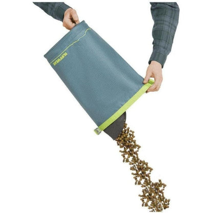 A person pouring pet food from the Ruffwear Kibble Kaddie in Slate Blue against a white background.