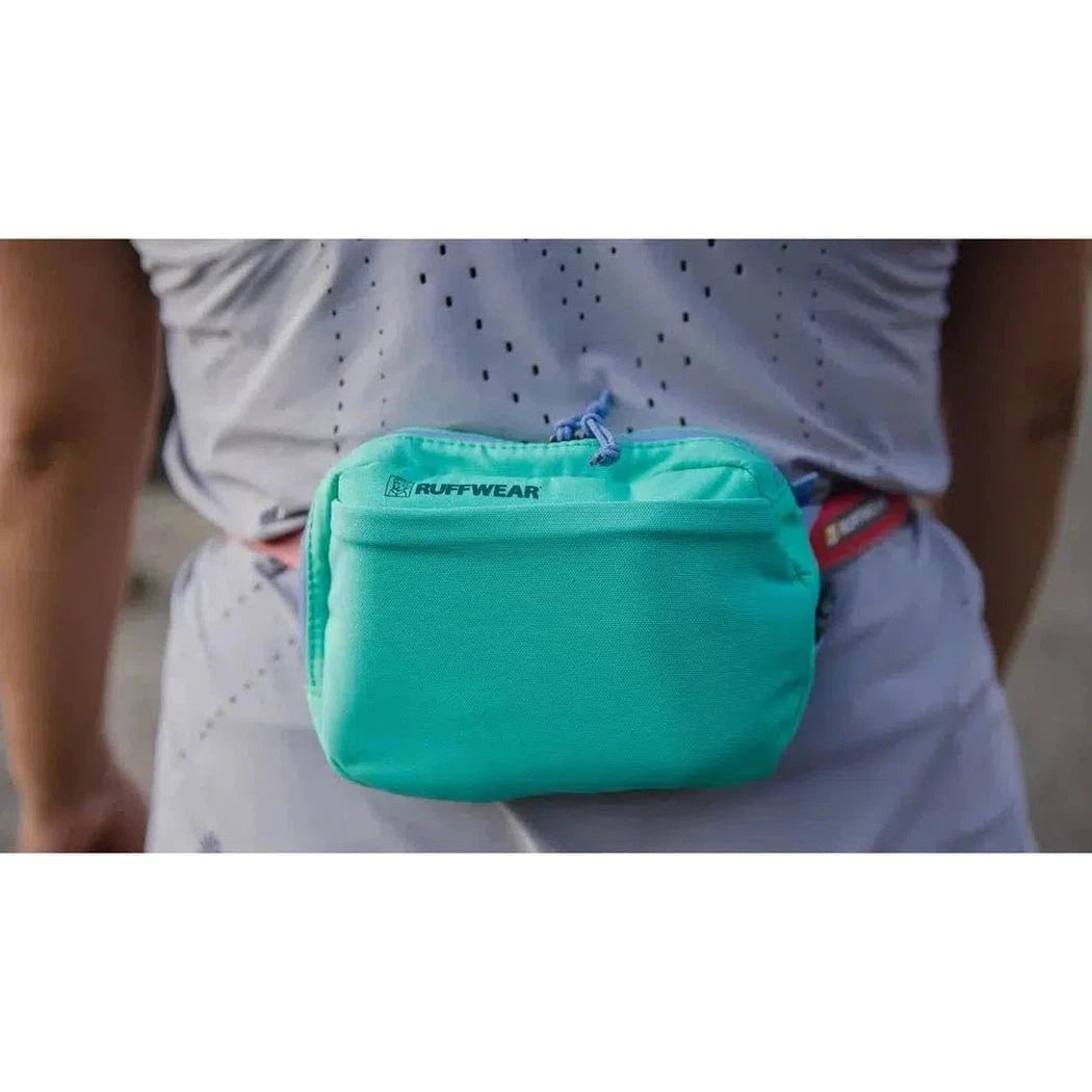 A model wears the Ruffwear Stash Bag Plus in Aurora Teal on their waist.