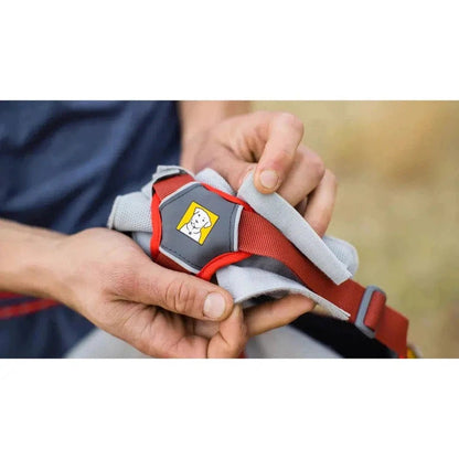 A person holds the Graphite Grey Ruffwear Swamp Cooler Core, showing its padded design and logo against a blurred outdoor background.