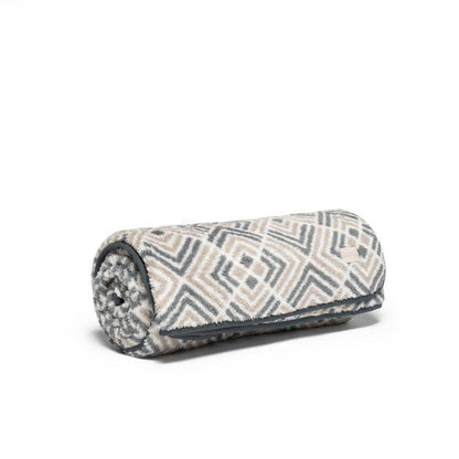 A rolled-up Rumpl Sherpa Fleece blanket in Kaleidoscope Stone pattern sits on a white background.