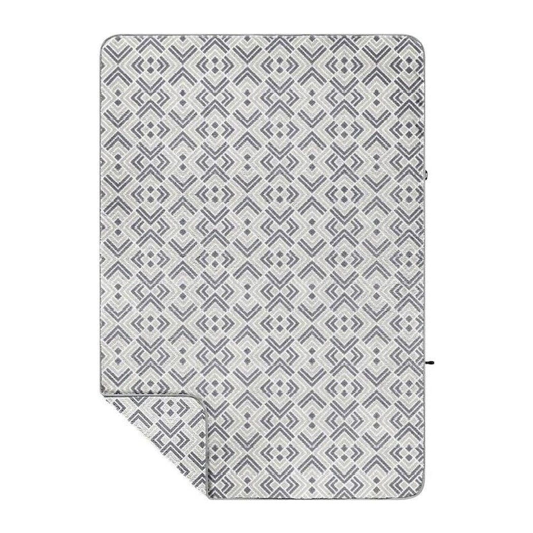 A flat lay of the Rumpl Sherpa Fleece in Kaleidoscope Stone showing the geometric pattern and folded corner.