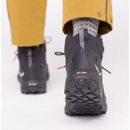 Back view of the Salewa Women's Pedroc Pro Powertex Mid Boot in Black/Black, showing the rugged outsole and model wearing it against a white background.