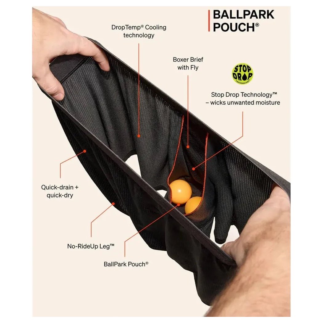A black Ballpark Pouch with two yellow balls inside is held open by a person's hands, showing features like quick-dry and no-ride-up leg.