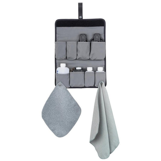 A hanging Sea To Summit Camp Kitchen Tool Kit - 10 Piece Set in Charcoal/Graphite with a gray towel and a gray cloth below it.