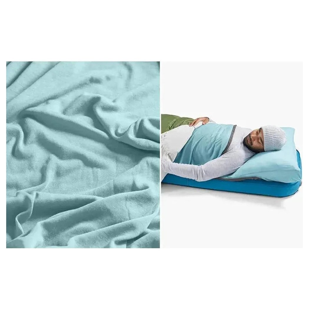 A close-up of the Sea To Summit Comfort Blend Sleeping Bag Liner - Rectangular in light blue, shown on a model sleeping on a blue mattress.