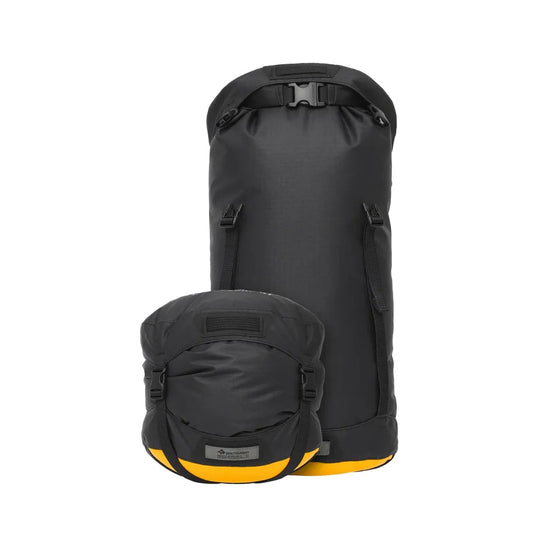 A front view of the Sea To Summit Evac Heavy Duty Compression Dry Bag in Jet Black with a buckle closure and yellow bottom, displayed against a white background.