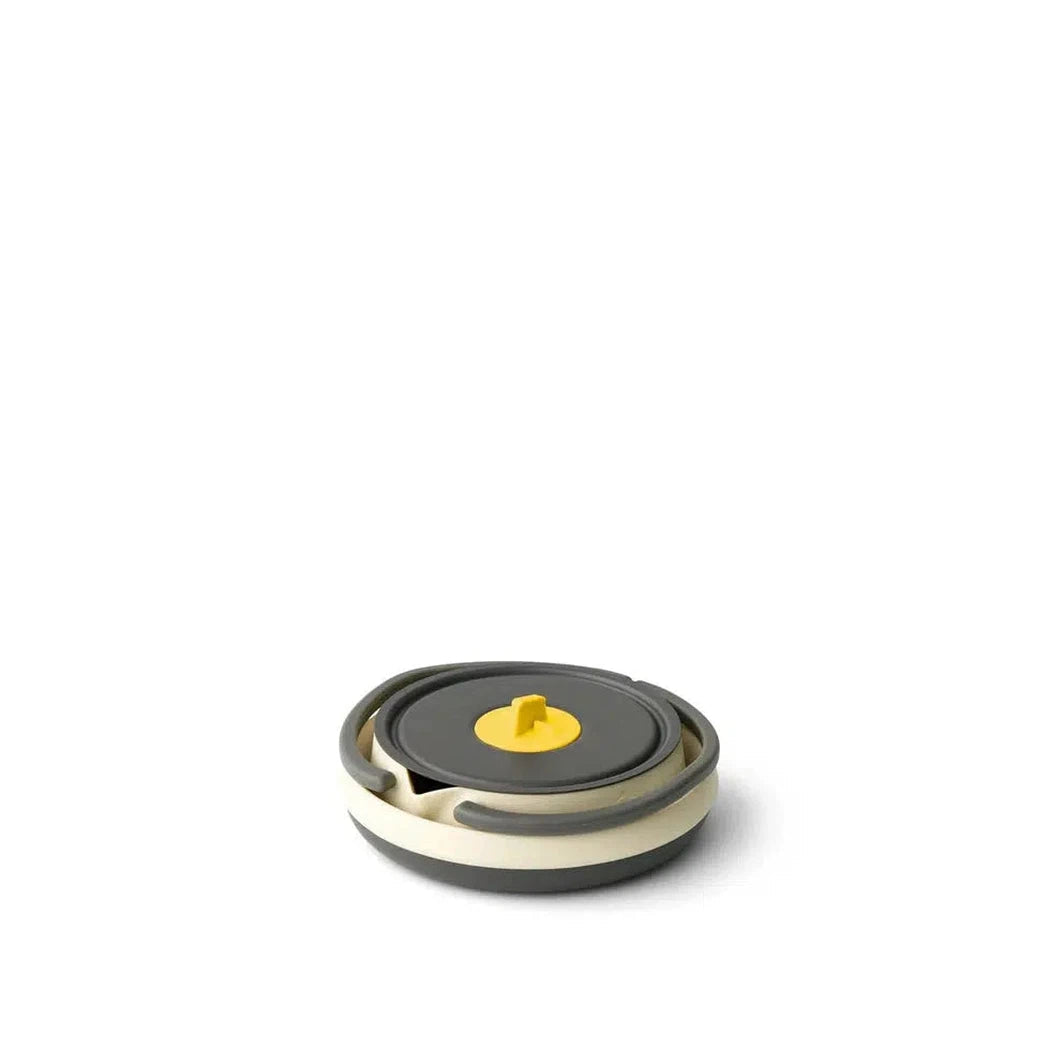 A top-down view of the Sea To Summit Frontier UL Collapsible Kettle - 1.1L with a charcoal/gray lid and yellow knob, set against a plain white background.