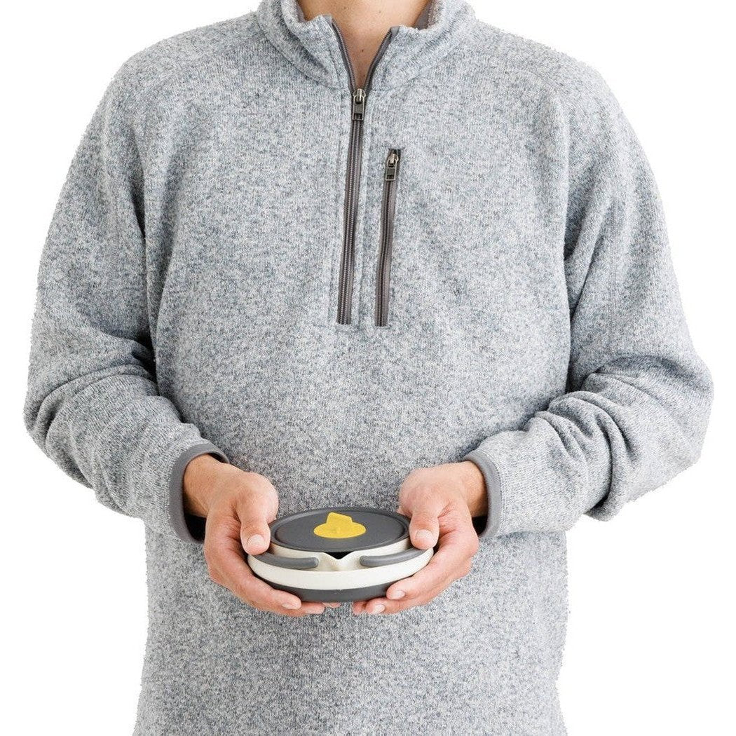 A person wearing a gray fleece holds the Sea To Summit Frontier UL Collapsible Kettle - 1.1L in front of a white background.