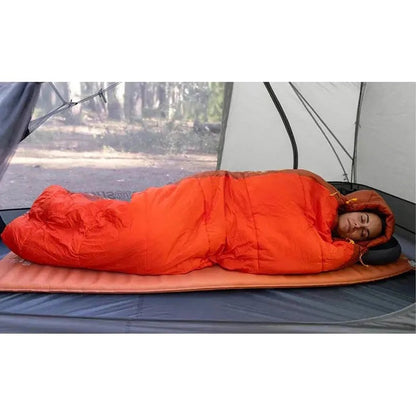 A woman sleeps in an orange Sea To Summit Hamelin Women's Synthetic Sleeping Bag inside a tent on a charcoal mat.