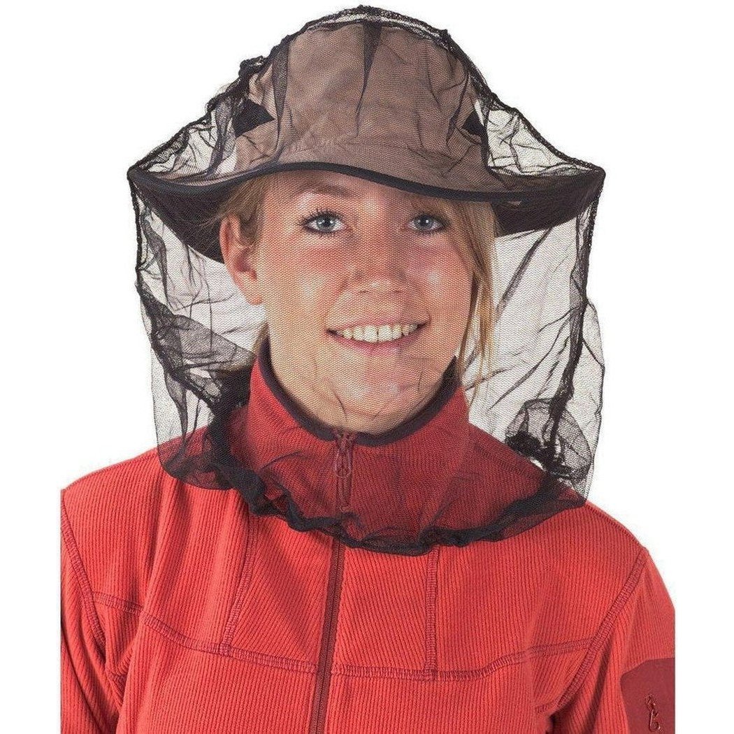 A woman wears the Sea To Summit Mosquito Head Net - Insect Shield with a black mesh and brown hat, against a white background.