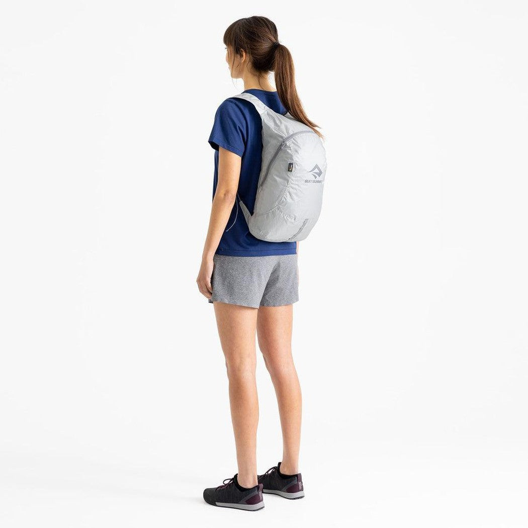 Side view of the Sea To Summit Ultra-Sil Day Pack in High Rise Grey on a model against a white background.