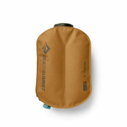 A top-down view of the Sea To Summit Watercell X 4L hydration reservoir in tan, showing the brand logo and a teal valve against a white background.