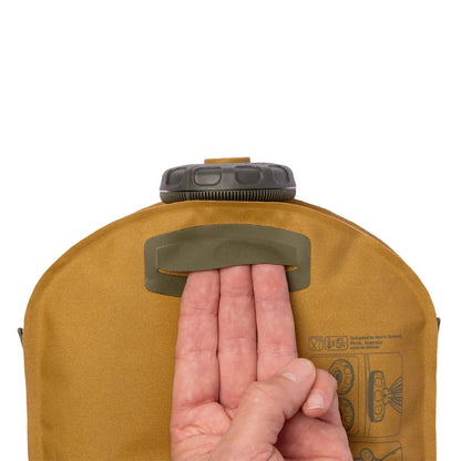 A hand grips the handle of the Sea To Summit Watercell X 4L reservoir against a white background.