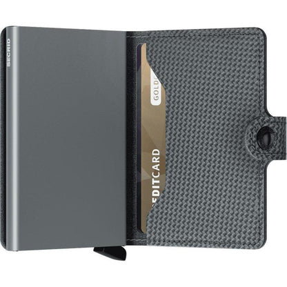 A charcoal colored SECRID Mini Wallet - Carbon open to show a card slot and snap closure.