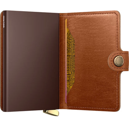 A side view of the SECRID Premium Miniwallet Emboss Lines + in Cognac showing the card slot and snap closure.