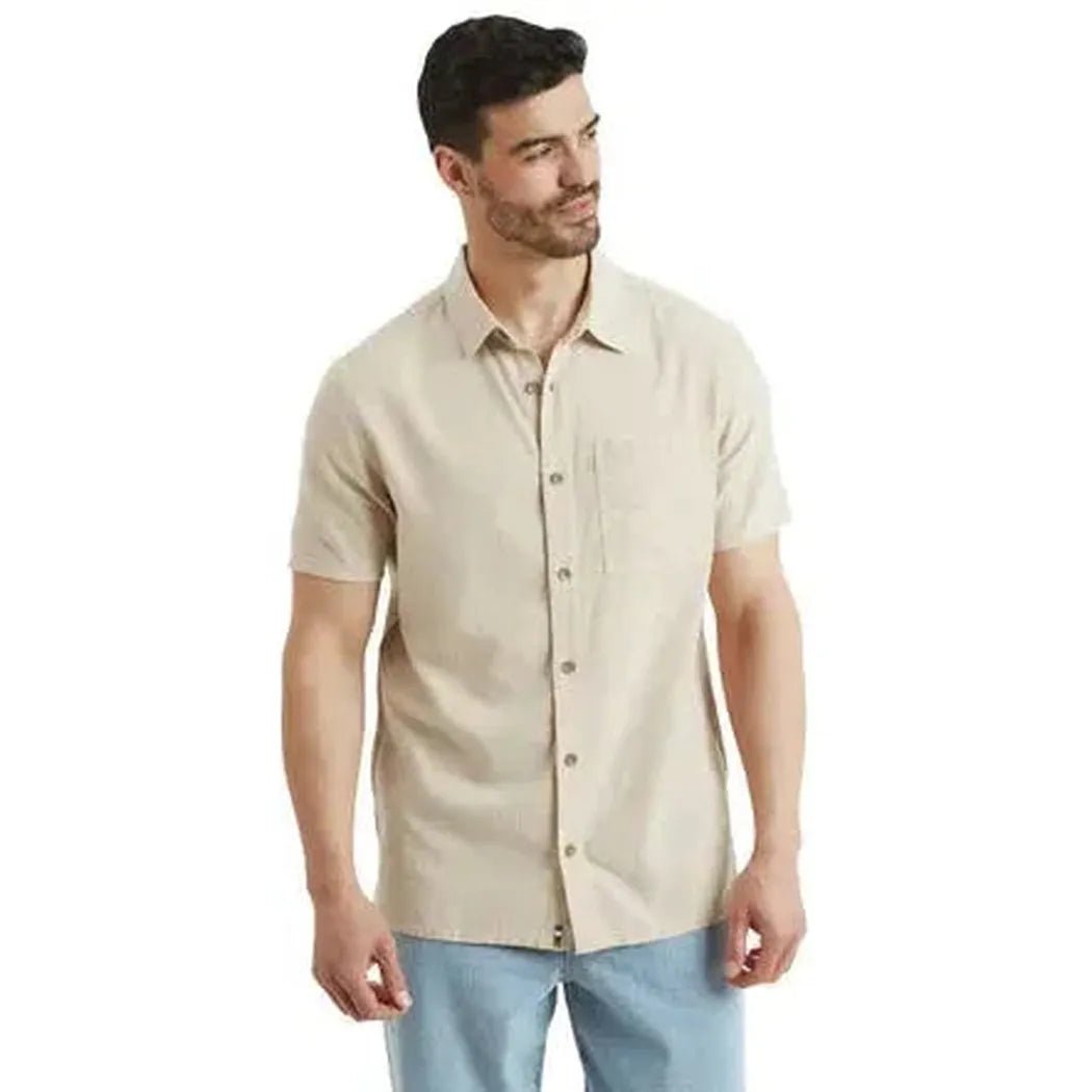 A front view of the Sherpa Adventure Gear Men's Daha Short Sleeve Shirt in Bardiya Sand on a model against a white background.