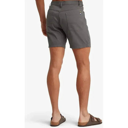 Back view of the Sherpa Adventure Gear Men's Dando 5 Pocket Short in Kharani Grey on a model wearing brown sandals against a white background.