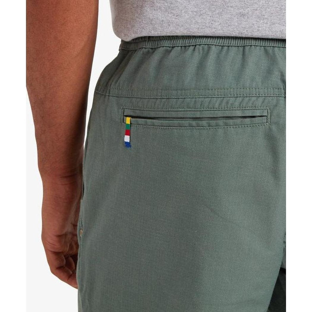 Back view of the Sherpa Adventure Gear Sample - Men's Ghoral Short in Bardiya Sand showing the zippered back pocket and model wearing it.