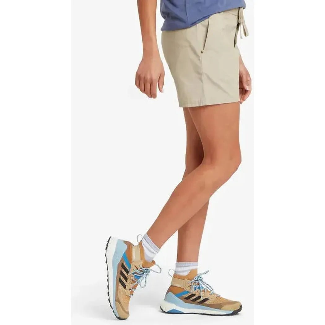 Side view of the Sherpa Adventure Gear Sample - Women's Ghoral Short in Bardaya Sand showing the drawstring waist and model wearing them against a white background.