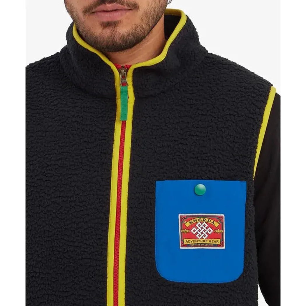 A close-up of the Sherpa Adventure Gear Samples - Men's Tarcho Vest in Black, showing the front pocket and zipper against a plain background.