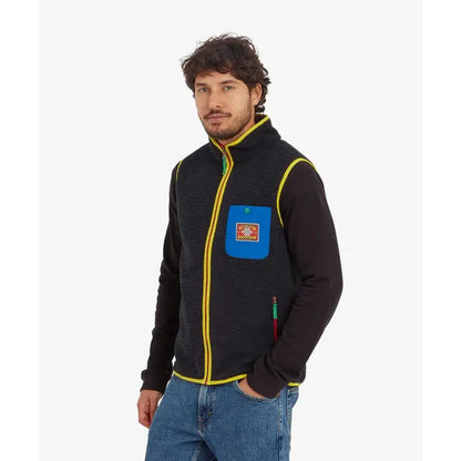 A man wearing the Sherpa Adventure Gear Samples - Men's Tarcho Vest in Black stands against a white background.