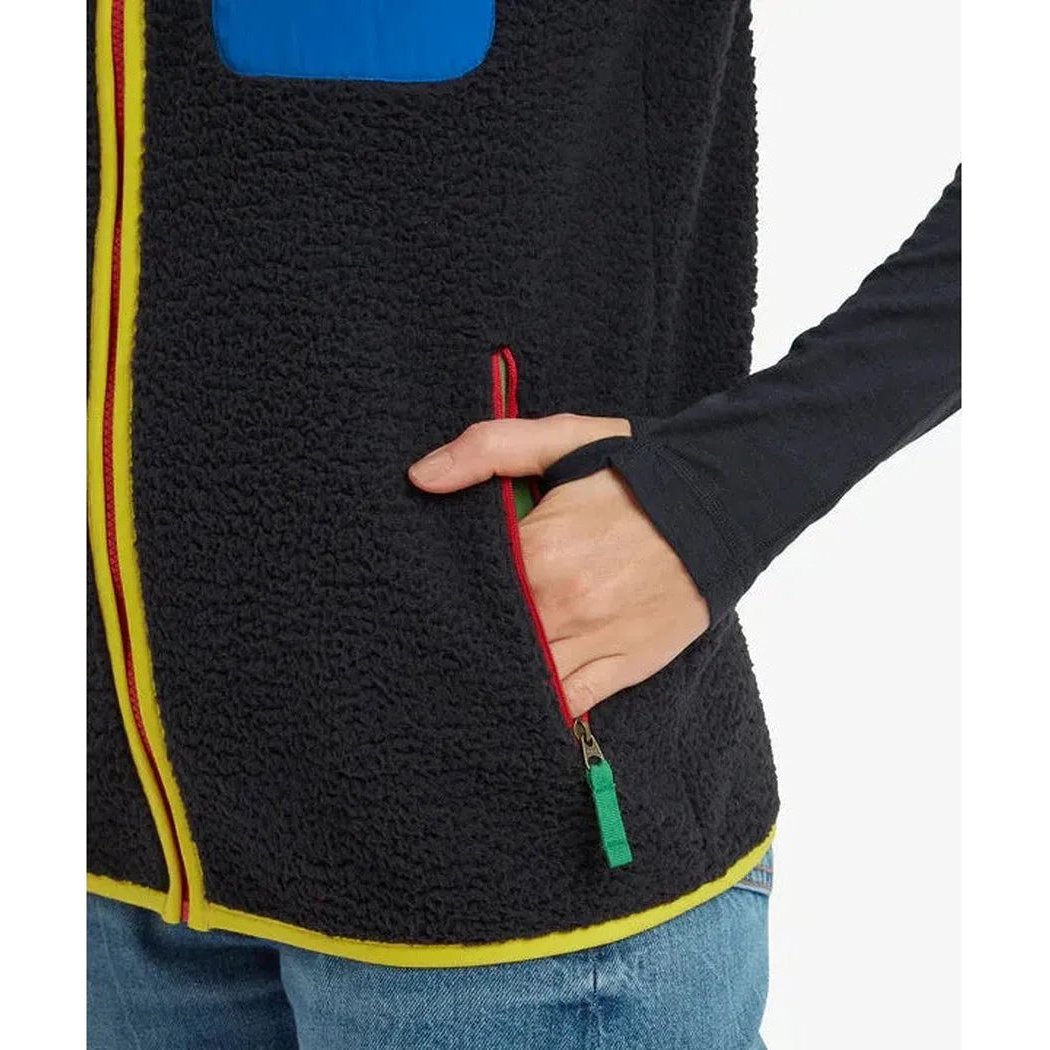 Side view of the Sherpa Adventure Gear Samples - Men's Tarcho Vest in Black showing the zippered pocket and model wearing it.