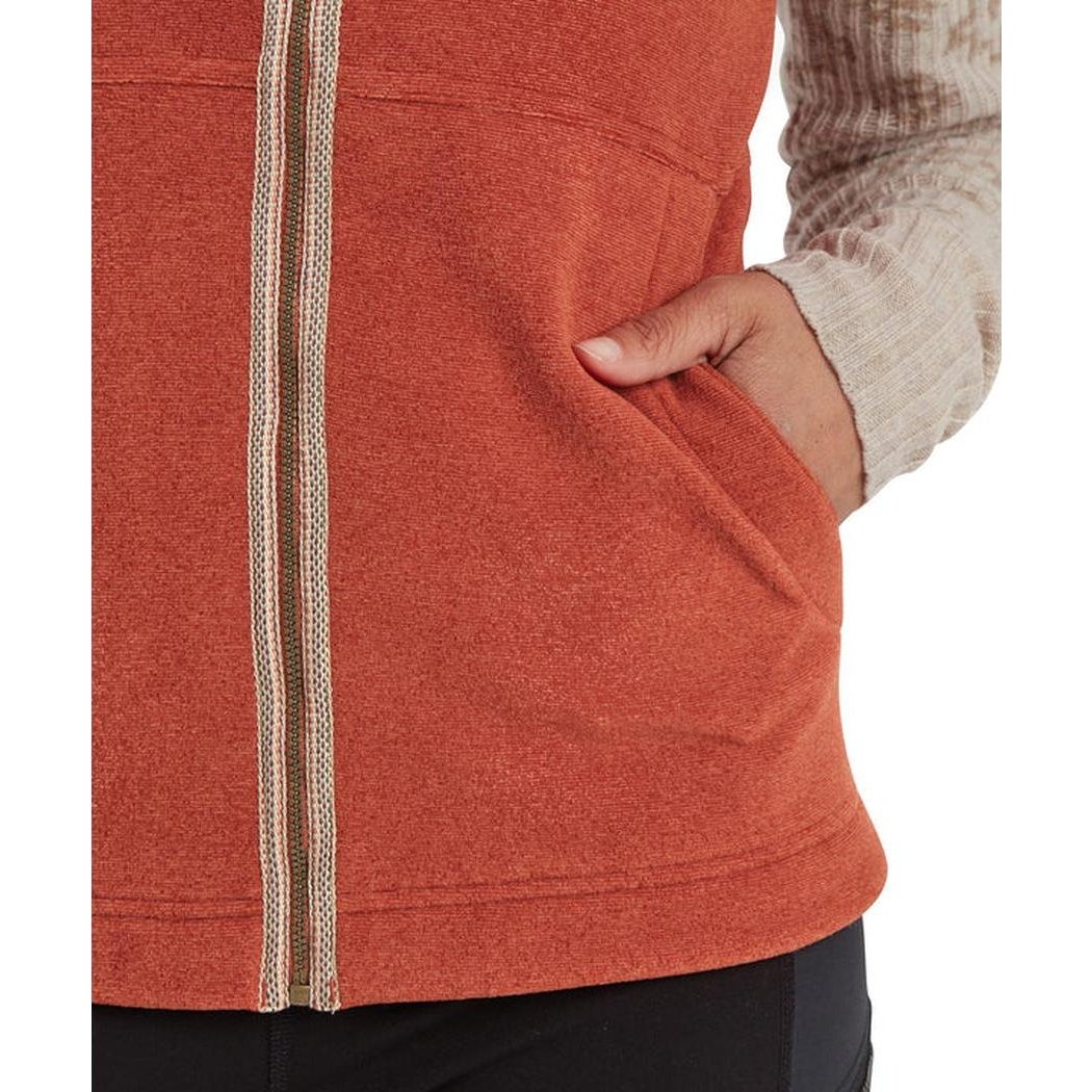 A close-up of the Sherpa Adventure Gear Women's Rolpa Eco Vest in Rust, showing the front zipper and a hand in the pocket.