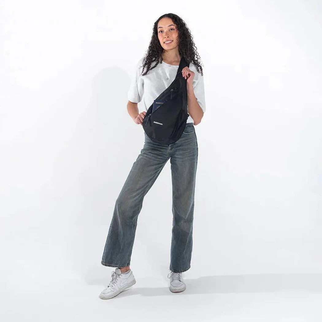 A model wearing the Sherpani Esprit AT Carbon bag in a side view against a white background.